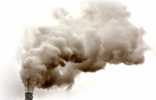 Pollution streams out of a factory chimney.